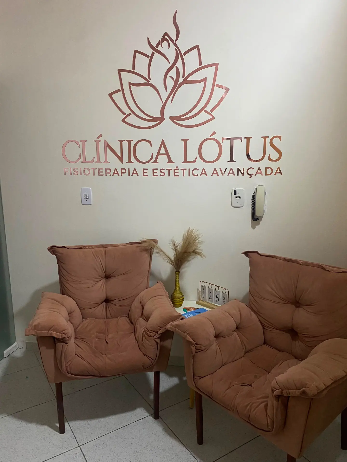 Recepção da Clínica Lótus com logotipo em rosé na parede